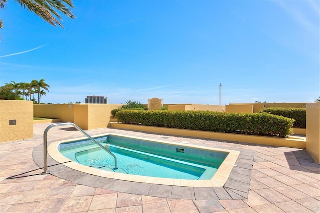 view of pool with a patio and a hot tub