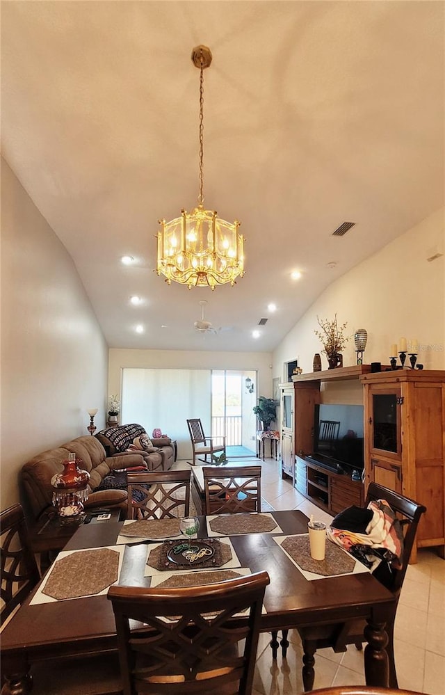 dining space with a notable chandelier, vaulted ceiling, and light tile patterned floors