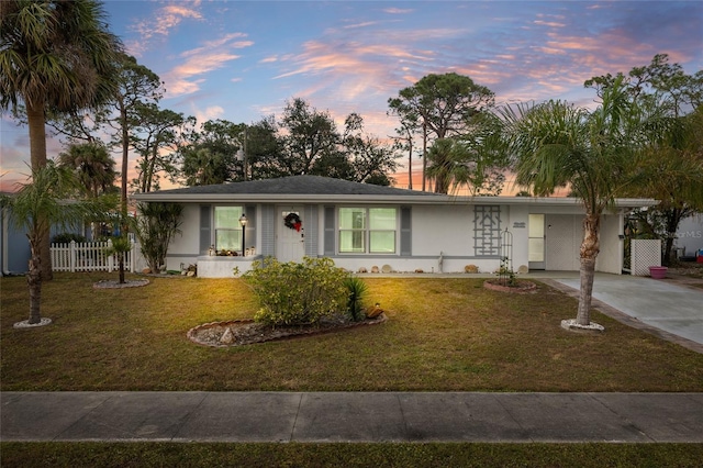 single story home featuring a carport and a lawn