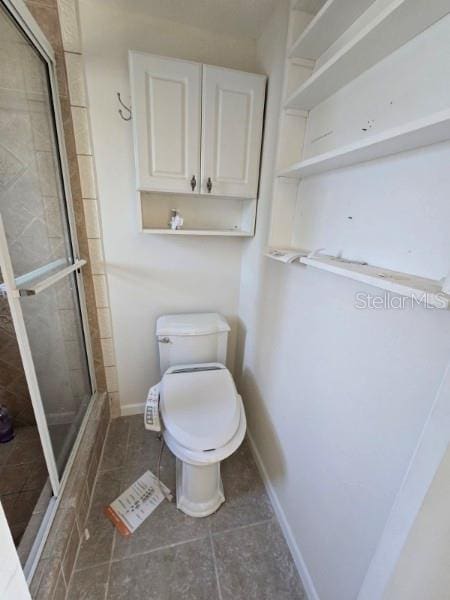 bathroom featuring toilet, tile patterned floors, and walk in shower