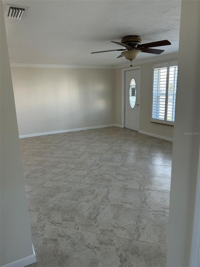 foyer entrance with ornamental molding and ceiling fan