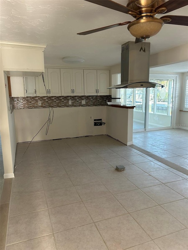 kitchen featuring white cabinetry, island range hood, kitchen peninsula, and light tile patterned flooring