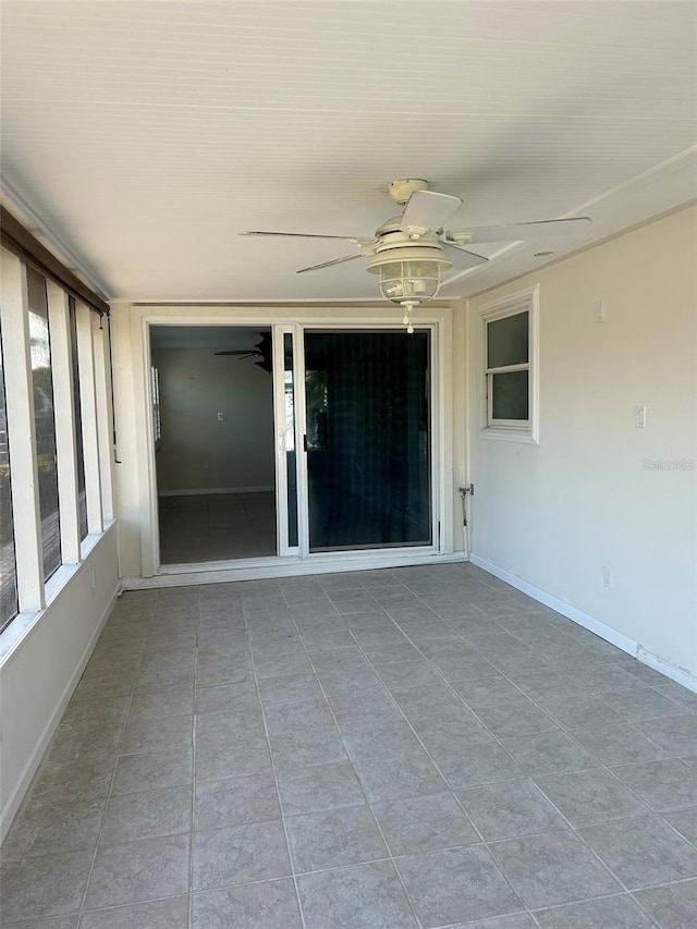 unfurnished sunroom with ceiling fan