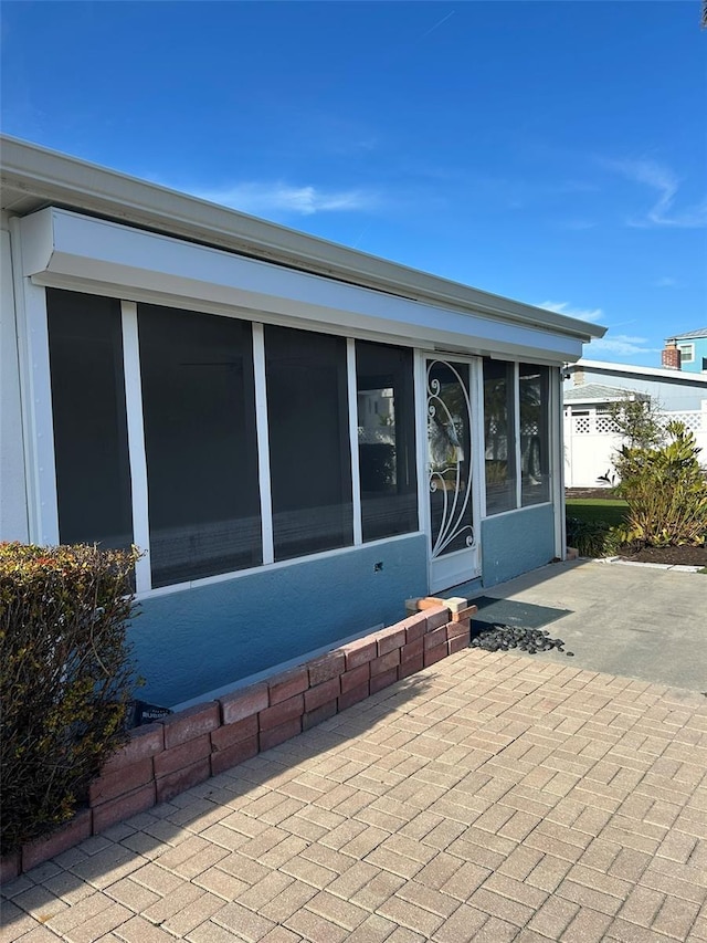 back of property with a sunroom and a patio
