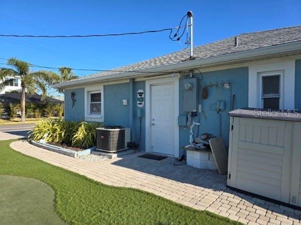 back of house featuring stucco siding and cooling unit