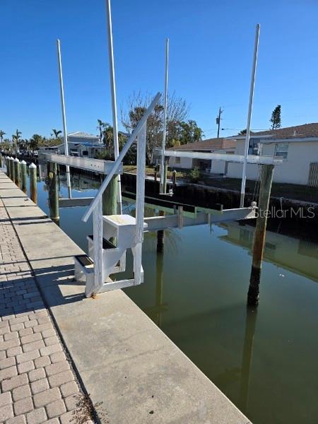view of dock with boat lift and a water view