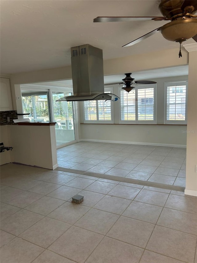 spare room featuring light tile patterned flooring, baseboards, and a ceiling fan