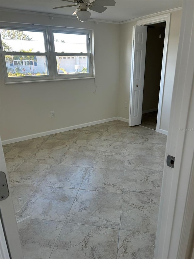 spare room with ornamental molding, baseboards, and a ceiling fan