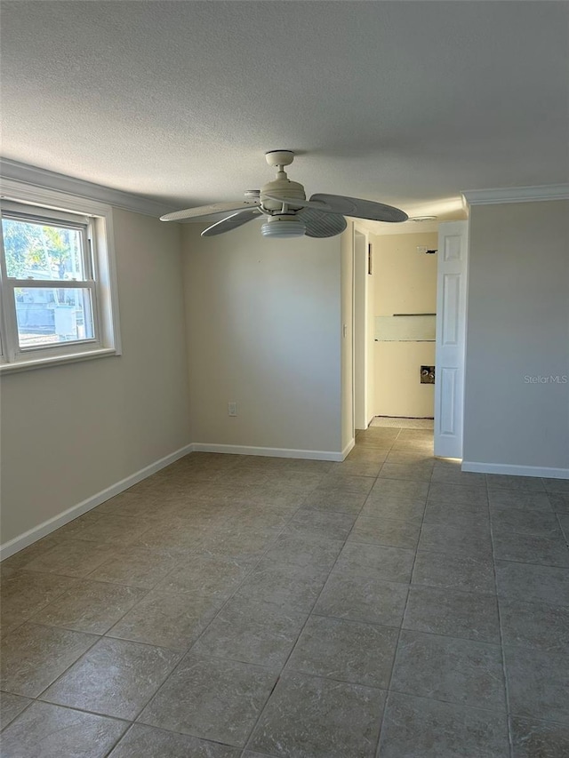 tiled empty room featuring baseboards, a ceiling fan, and a textured ceiling