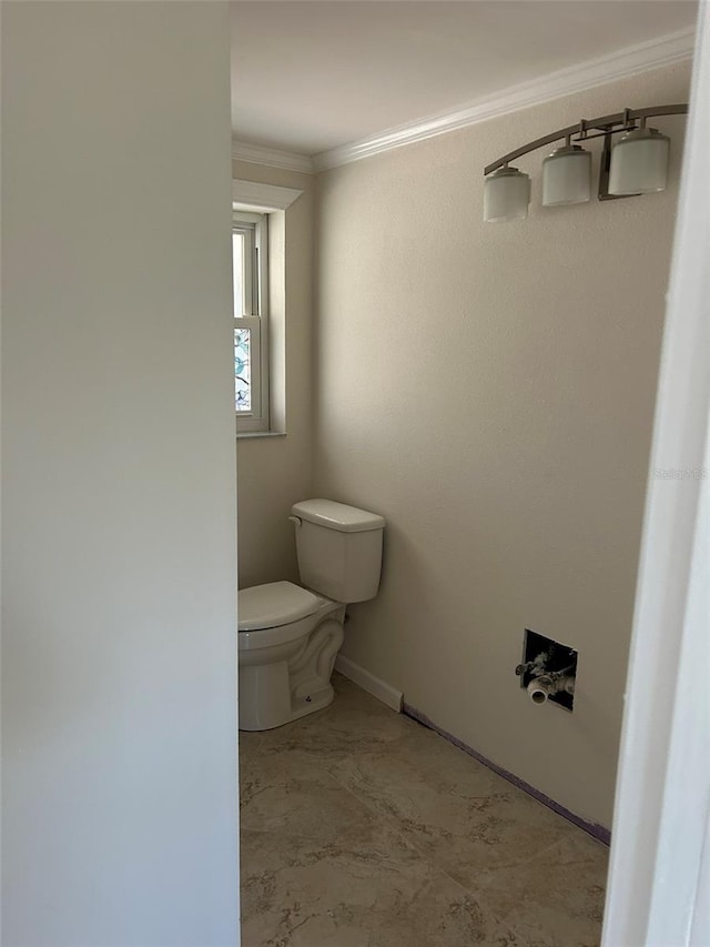 bathroom featuring baseboards, ornamental molding, and toilet