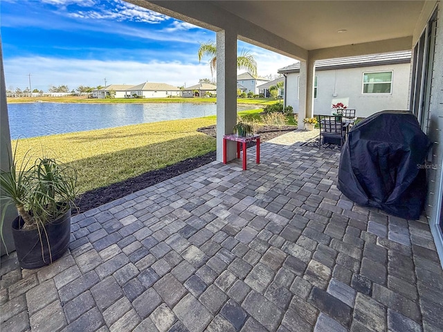 view of patio featuring area for grilling and a water view