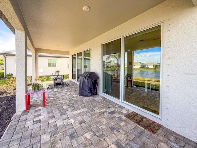 view of patio / terrace with grilling area and a water view