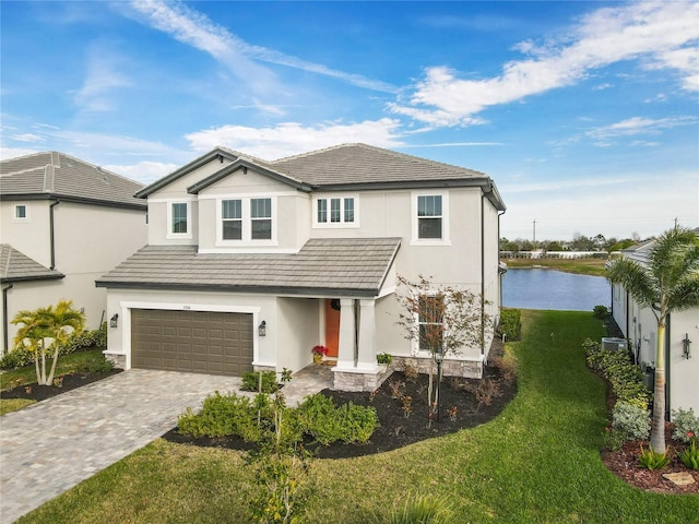 view of front facade featuring a garage, a front yard, and a water view