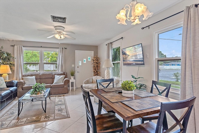 tiled dining area featuring ceiling fan with notable chandelier