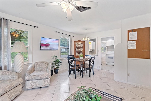 dining space featuring light tile patterned floors and ceiling fan with notable chandelier