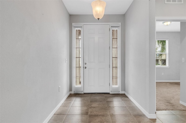 foyer entrance with tile patterned flooring, visible vents, and baseboards