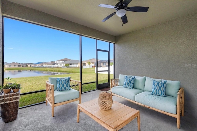 sunroom / solarium featuring ceiling fan and a water view