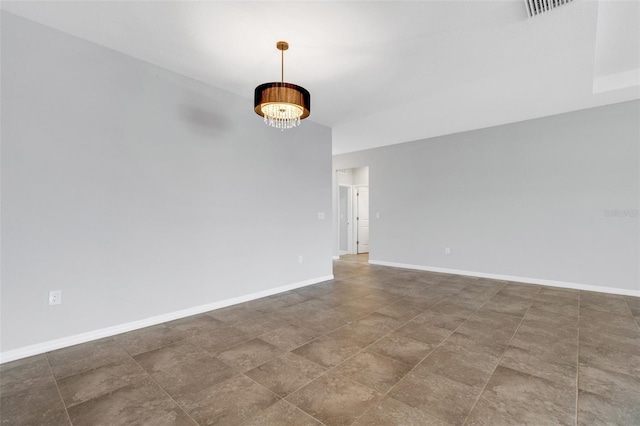 unfurnished room featuring a chandelier