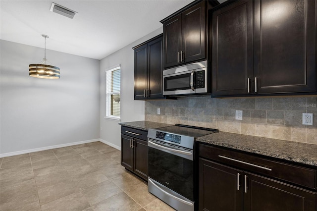 kitchen featuring dark brown cabinetry, stainless steel appliances, and dark stone counters