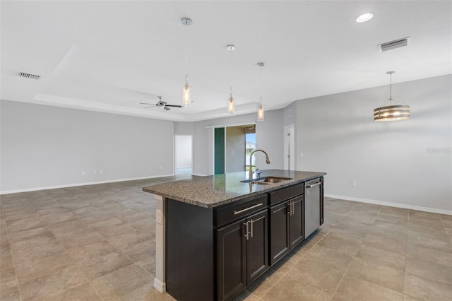 kitchen with ceiling fan, sink, hanging light fixtures, stainless steel dishwasher, and a kitchen island with sink