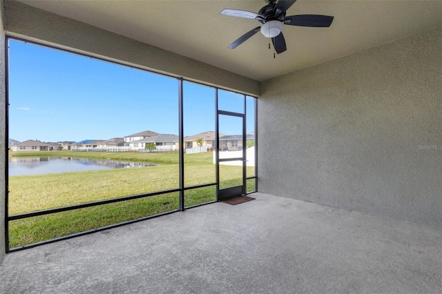 unfurnished sunroom featuring a water view and ceiling fan