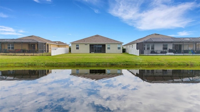 rear view of property with a water view and a lawn