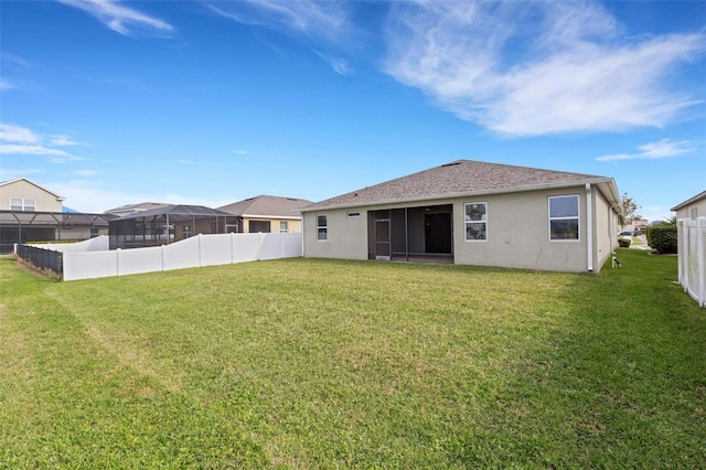 rear view of property with a yard and a sunroom