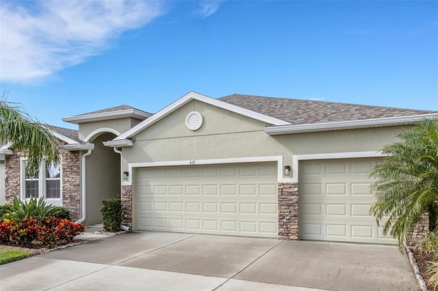 view of front of property featuring roof with shingles, stucco siding, an attached garage, stone siding, and driveway