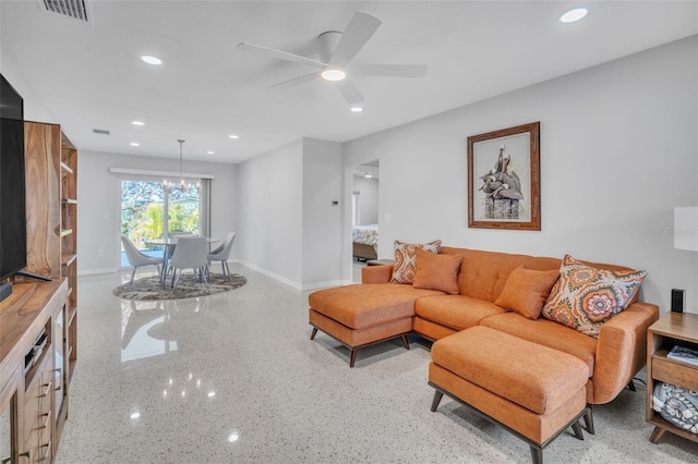 living room featuring ceiling fan with notable chandelier