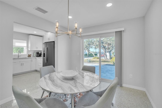 dining space with a notable chandelier and sink