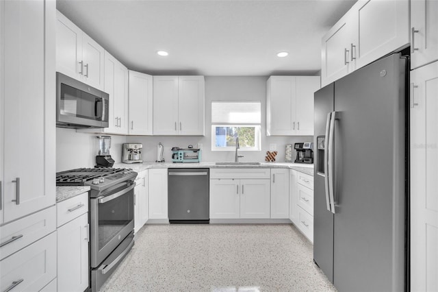 kitchen with sink, white cabinets, and stainless steel appliances