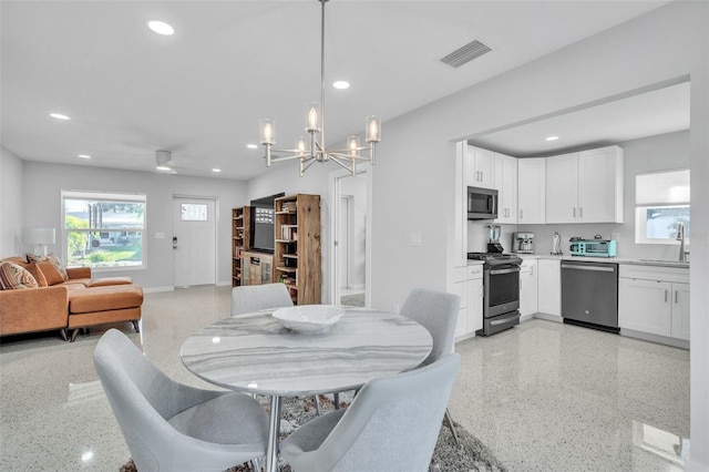 dining space with a notable chandelier and sink