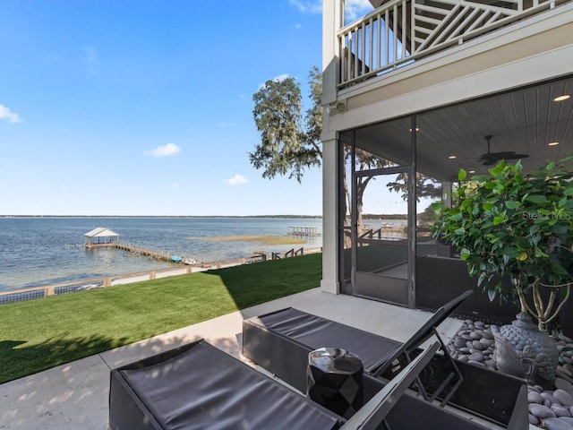 view of patio featuring ceiling fan, a water view, and a balcony