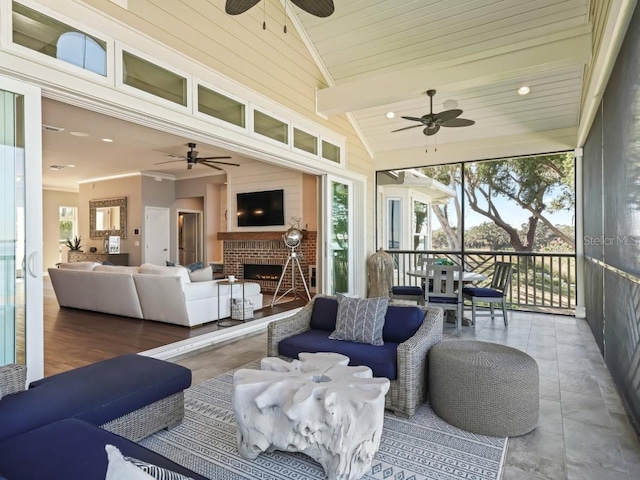 sunroom / solarium with a brick fireplace, vaulted ceiling, and plenty of natural light