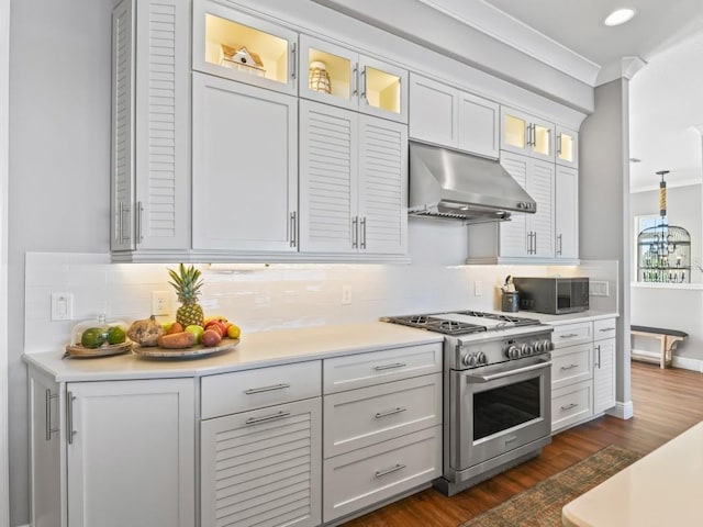 kitchen featuring decorative light fixtures, high end stove, extractor fan, and tasteful backsplash