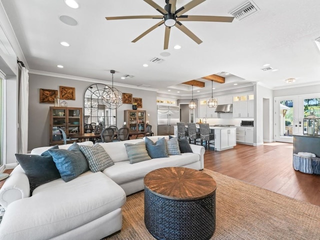 living room with french doors, ceiling fan with notable chandelier, hardwood / wood-style flooring, and ornamental molding