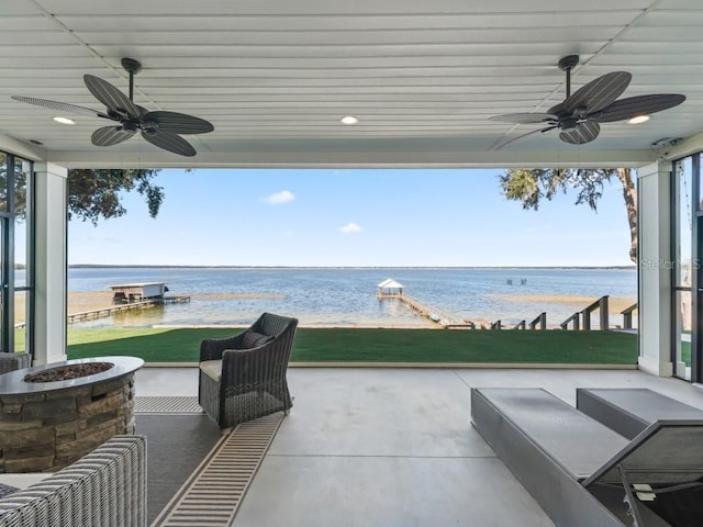 view of patio featuring a fire pit, ceiling fan, and a water view