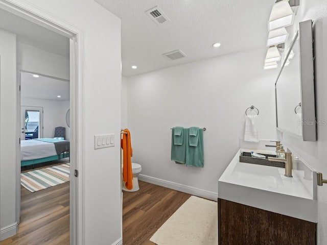 bathroom featuring hardwood / wood-style floors, vanity, a textured ceiling, and toilet