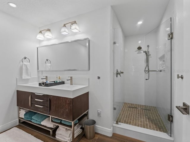 bathroom with hardwood / wood-style floors, vanity, and an enclosed shower