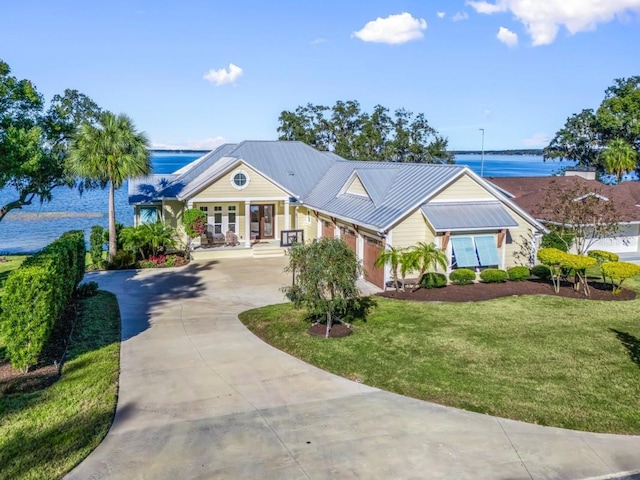 view of front of property featuring a porch, a water view, and a front yard