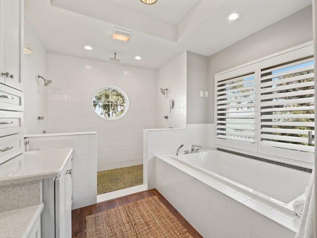 bathroom with vanity, hardwood / wood-style flooring, and independent shower and bath