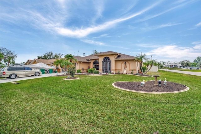 mediterranean / spanish home featuring a front yard