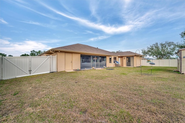 rear view of property featuring a lawn