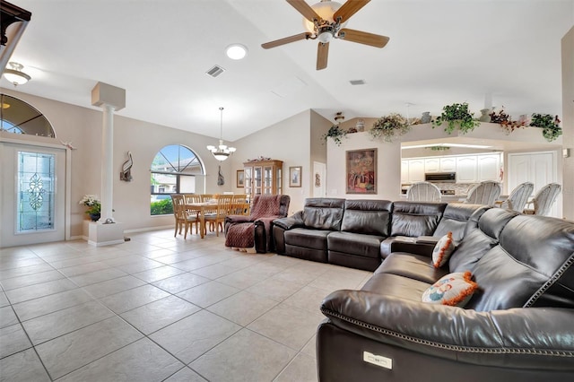 tiled living room with ceiling fan with notable chandelier and lofted ceiling