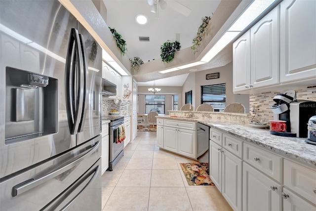 kitchen with white cabinetry, stainless steel appliances, light tile patterned floors, and tasteful backsplash