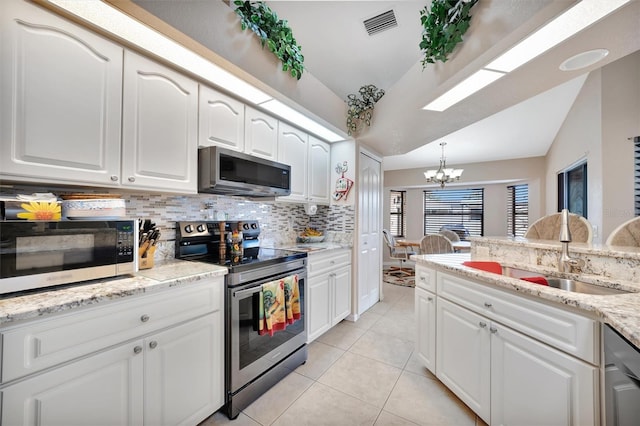 kitchen with sink, white cabinets, stainless steel appliances, and vaulted ceiling