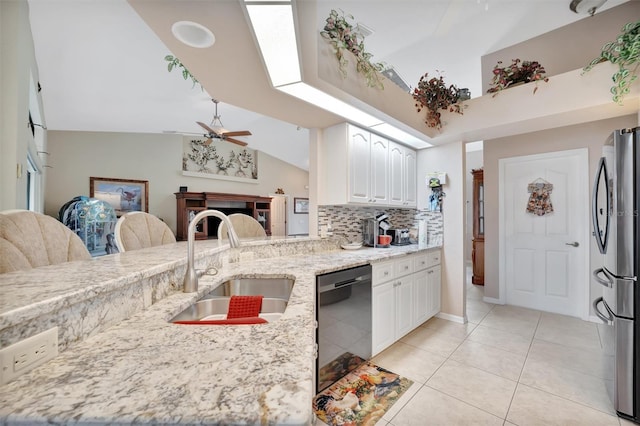 kitchen featuring sink, light stone countertops, black dishwasher, white cabinetry, and stainless steel refrigerator