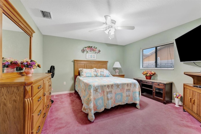 bedroom with ceiling fan, carpet, and a textured ceiling