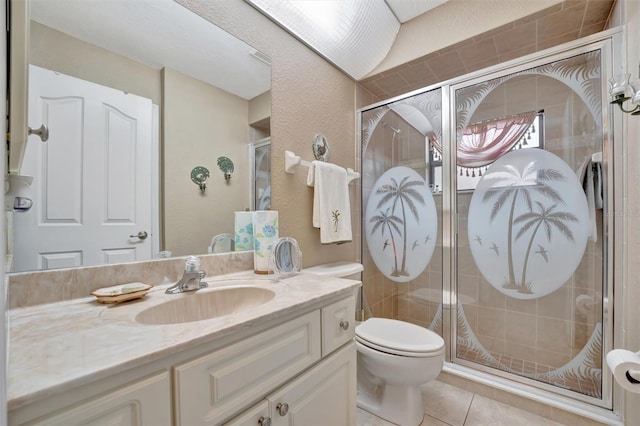 bathroom with toilet, vanity, tile patterned floors, and a shower with shower door