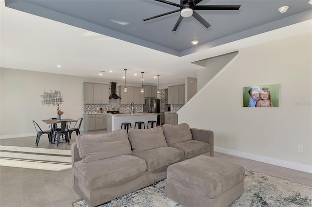 living room featuring sink, ceiling fan, and light tile patterned flooring